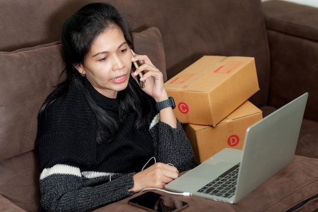 Online verzending aziatische vrouw startende eigenaar van een klein bedrijf de checklist accepteert de bestelling online