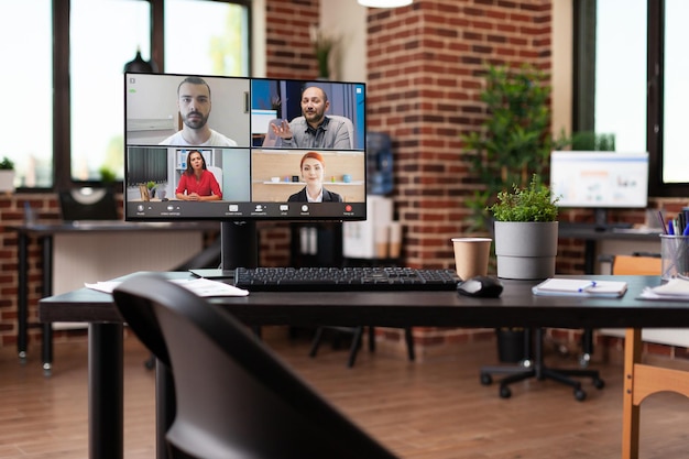 Фото Онлайн-видеозвонок с коллегами по работе на компьютере в пустом деловом офисе. монитор с удаленной онлайн-видеоконференцией, используемый для корпоративных встреч с бизнесменами на столе.