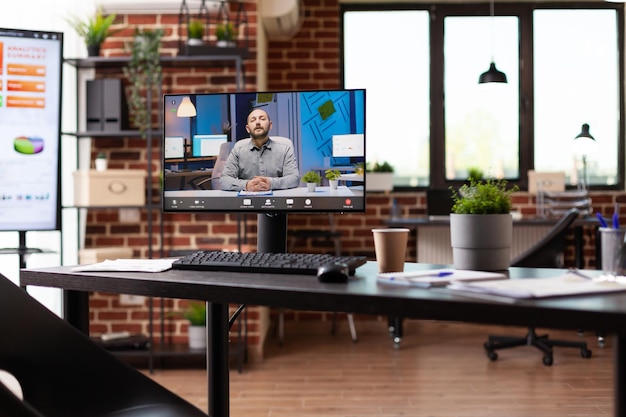 Online video conference with business man on computer, nobody\
in office. remote video call on monitor to have teleconference\
meeting with colleague in empty workplace. telecommunication