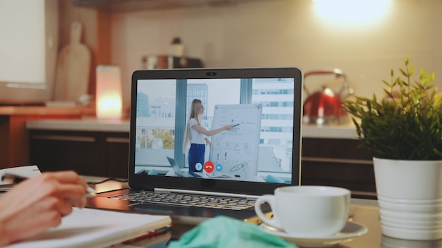 Online videoconferentie op laptop met vrouwelijke spreker in kantoor aan huis