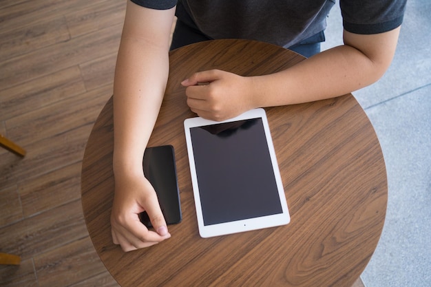 Online werken vanuit huis draagbaar kantoorconcept Bovenaanzicht hand van jonge man aan het werk op tablet