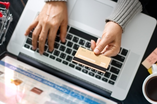 Online winkelconcept. Vrouw die gouden creditcard in hand en online het winkelen houdt