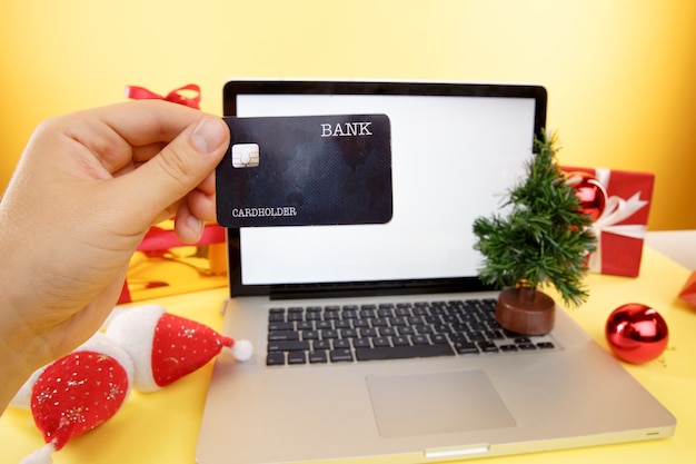 Online winkelen concept. creditcard en laptop met kerstcadeaus en dozen.