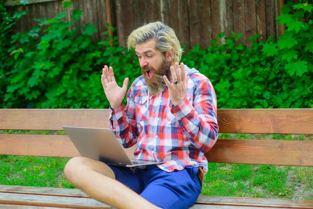 공원 디지털 작업에서 노트북을 들고 온라인에서 흥분한 남자 야외에서 노트북을 들고 흥분한 남자