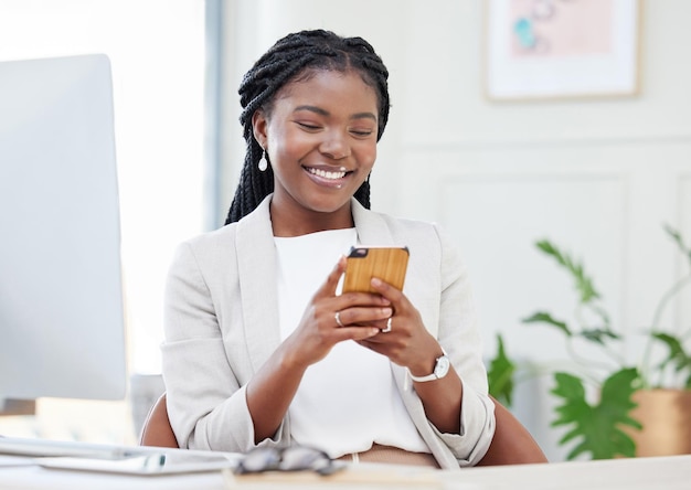 온라인 세계가 손짓합니다. 스마트폰으로 문자를 보내는 아름다운 아프리카 여성 사업가의 사진.