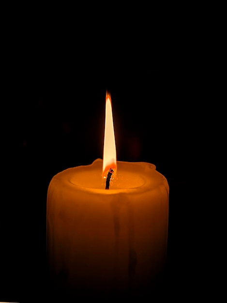 Photo only light candle burning brightly in the black background