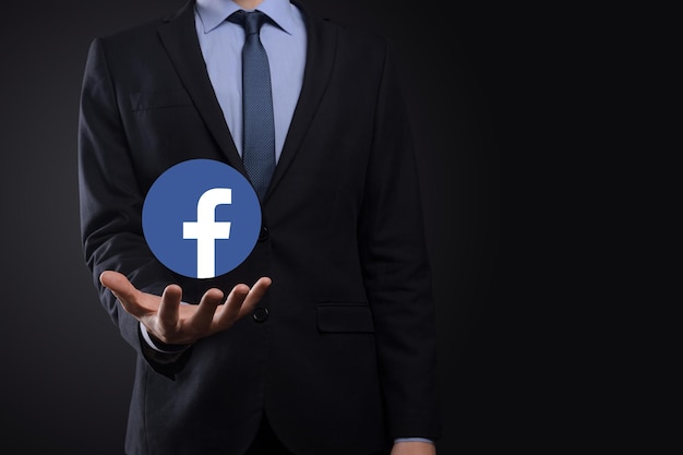 Onok,Ukraine - July 14,2021:Businessman holds, clicks, Facebook icon in his hands.Social network.global network and data customer connection.international network.