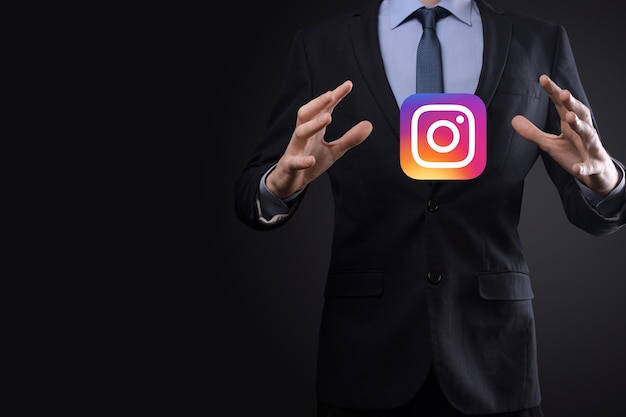 ウクライナ、オノク-2021年7月14日：ビジネスマンは、INSTAGRAMアイコンを手に持ってクリックします。ソーシャルネットワーク。グローバルネットワークとデータ顧客接続。国際ネットワーク。