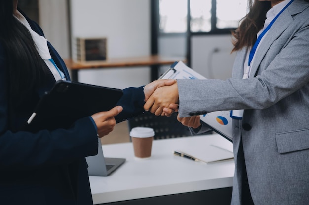 Onroerend goedmakelaar en klant schudden elkaar de hand na het ondertekenen van contractdocumenten voor de aankoop van onroerend goed Bankmedewerkers feliciteren Concept hypotheeklening goedgekeurd