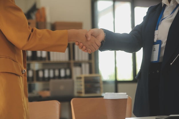 Onroerend goedmakelaar en klant schudden elkaar de hand na het ondertekenen van contractdocumenten voor de aankoop van onroerend goed Bankmedewerkers feliciteren Concept hypotheeklening goedgekeurd