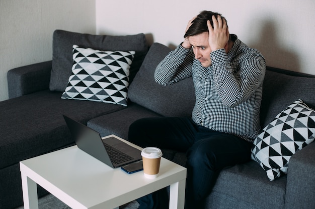 Onrustige man aan het werk op zijn computer vanuit huis