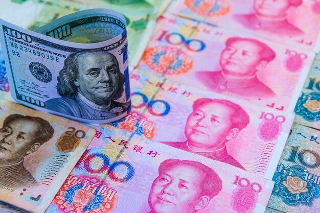 Ons Dollarbankbiljet die zich boven Chinese Yuansbankbiljetten bevinden.