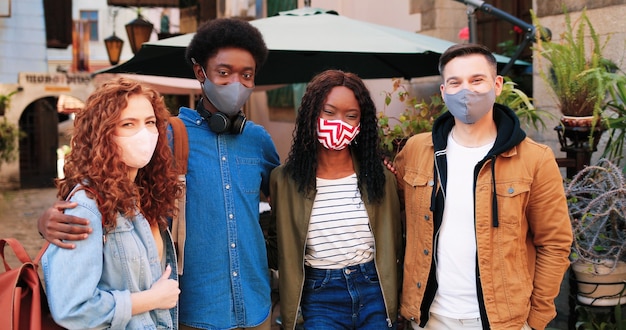 Ons eenheidsgezelschap van beste vrienden met beschermende maskers die samen tijd doorbrengen in de stad tijdens...