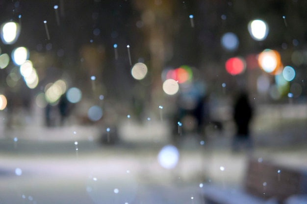 Onscherpe achtergrond Uitzicht op de stad lichten vallende sneeuw nacht straat bokeh vlekken