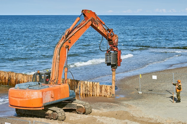 Ð¡onstruction of breakwaters from tree trunks on the sea coast.