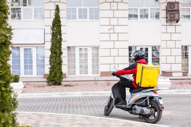 ?ontactless food delivery to customers home. Delivery service worker with thermal backpack quick delivering food at doorstep in quarantine from restaurant, supermarket or cafe . Online ordering food