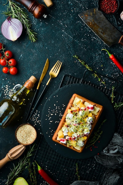 Ontbijt Belgische wafels met brie kaas feta en parmezaan Op een zwart stenen bord