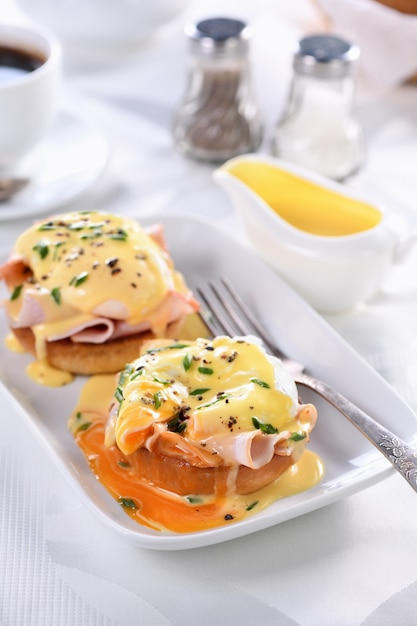 Ontbijt. Beste Eggs Benedict. gebakken Engels broodje, ham, gepocheerde eieren en heerlijke Hollandaise botersaus