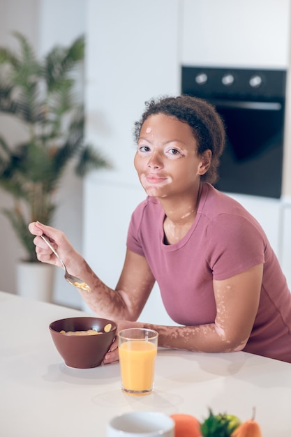 Ontbijt. Donkere jonge vrouw die thuis ontbijt