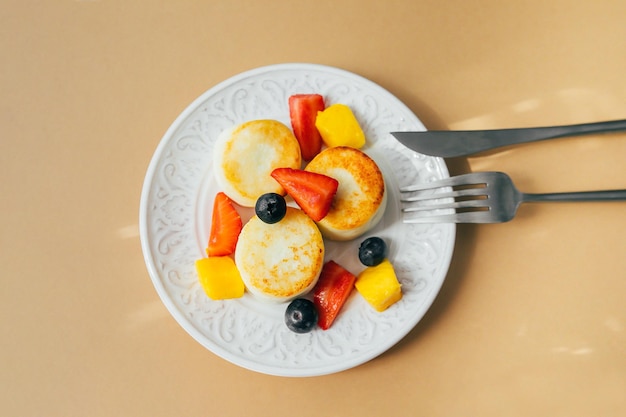 Foto ontbijt eten concept kwark pannenkoeken op plaat syrniki met berry bovenaanzicht