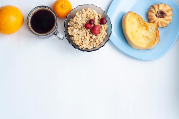 Foto ontbijt, havermout met bessen, koffie, fruit en gebak, plat leggen, kopie ruimte