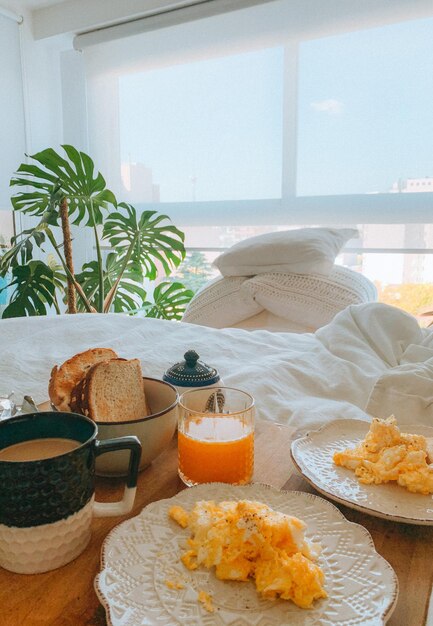 Foto ontbijt in bed in een kamer met planten.