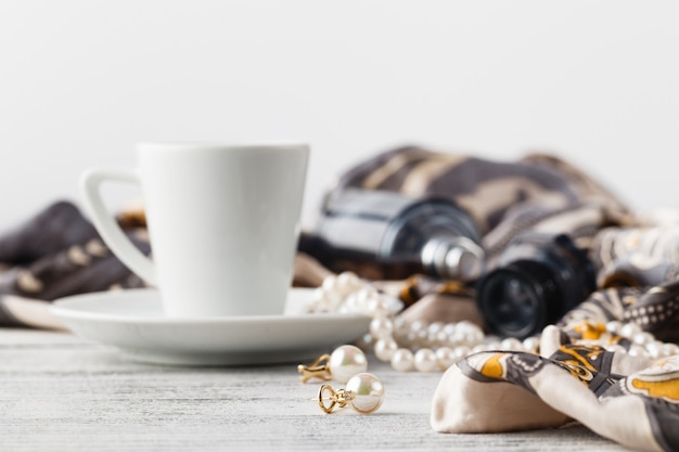 Ontbijt in café met koffiekopje en sjaal op tafel