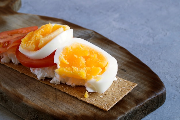 Ontbijt, knäckebroden met kaas, tomaten en eieren.