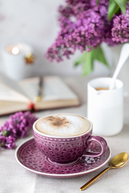 Ontbijt kopje koffie, wafels, melk en room en lila bloemen. Ochtend