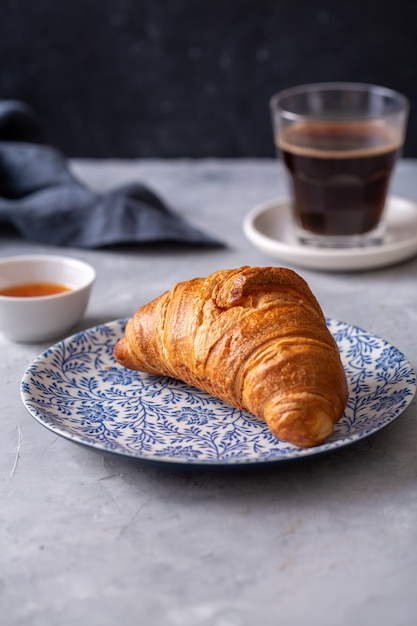 Ontbijt met croissant en zwarte koffie