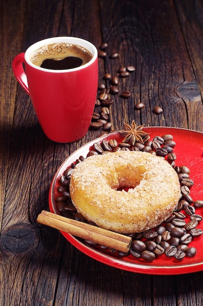 Ontbijt met donut en warme koffie op donkere houten tafel