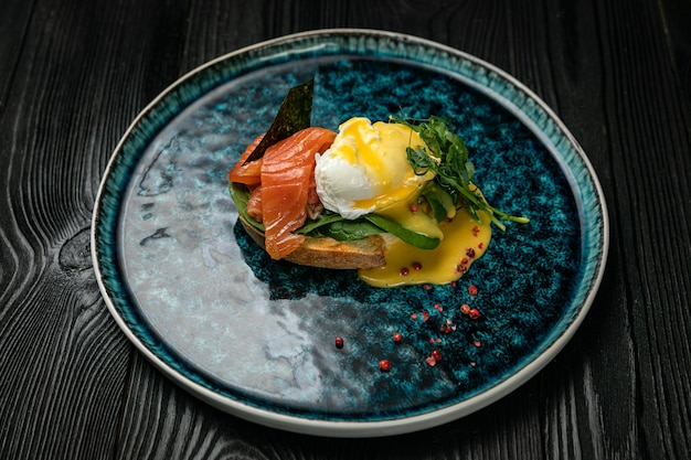 Ontbijt met eierkruiden en zalm op een ronde plaat