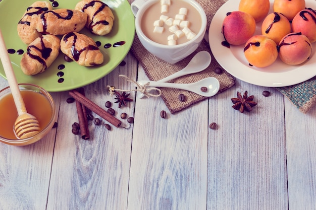 Ontbijt met koffie, croissants, abrikozen, honing, kaneel en anijs