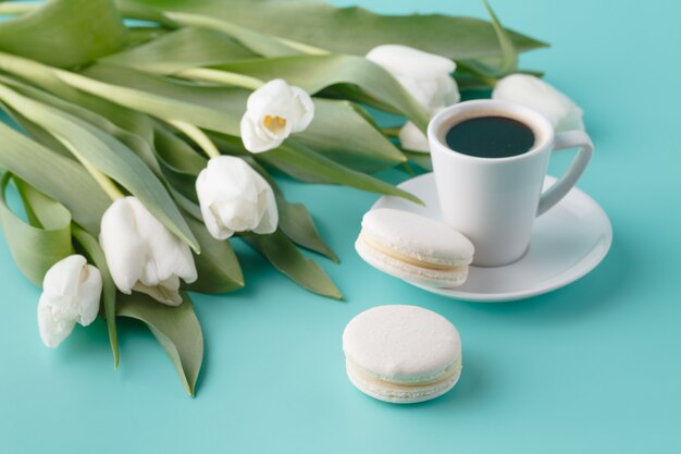 Ontbijt met koffiekopje en witte tulpen op de vlakte