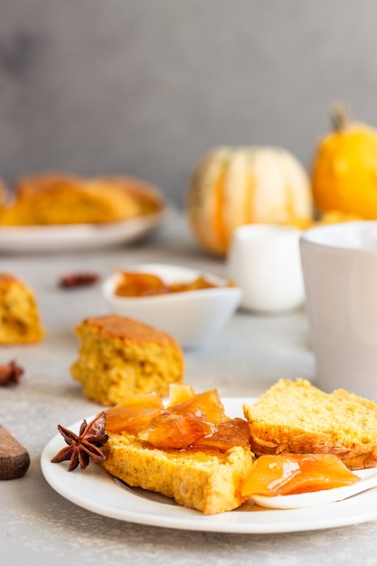 Ontbijt met pittige pompoenscones, een kopje thee en melk.