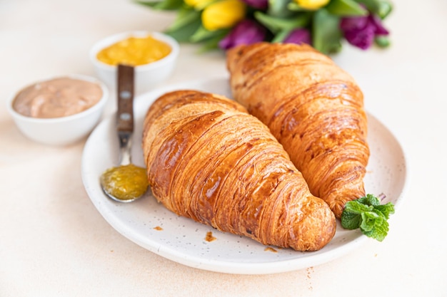 Ontbijt met verse croissants, chocoladeroomjam en tulpen Mooie romantische compositie