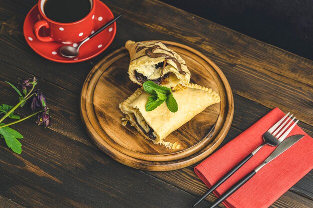 Ontbijt met zoete chocolade calzone in sandwichformaat en koffie geserveerd op een donkere houten tafel