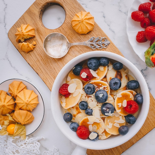 Ontbijt, Mini pannenkoeken met aardbeien, croissants en avocado, Heerlijk zomers eten, Bovenaanzicht op een marmeren achterkant