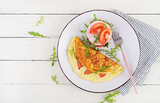 Ontbijt. Omelet met tomaten, kaas en sandwich met gekookte worst. Frittata - Italiaanse omelet. Bovenaanzicht, overhead