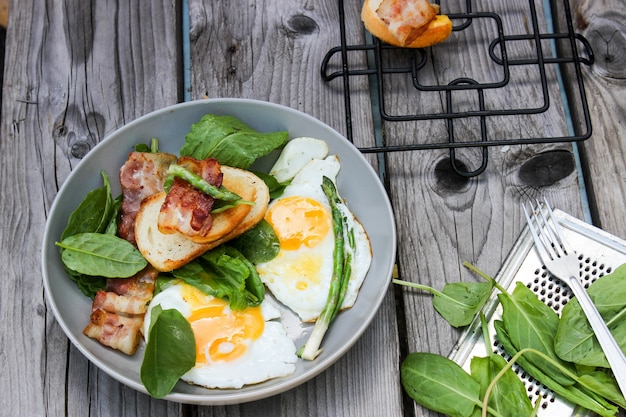 Foto ontbijt op een bord roerei met geroosterd brood, spek en aromatische kruiden