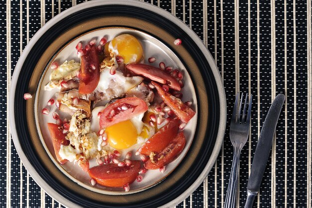 Ontbijt op een bord - spek met tomaten en eieren - bovenaanzicht