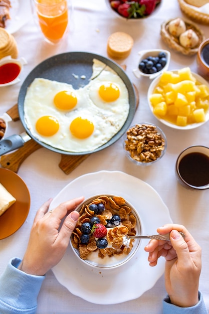 Ontbijt op tafel bovenaanzicht Eten op tafel bovenaanzicht Muesli met bessen Gebakken eieren Maaltijddag