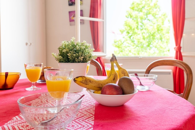 Ontbijt op tafel met een tafelkleed in de woonkamer thuis gezond ontbijt met sappen en fruit en curasans