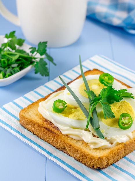 Ontbijt sandwich met eieren, parsly, groene ui en groene chili peper