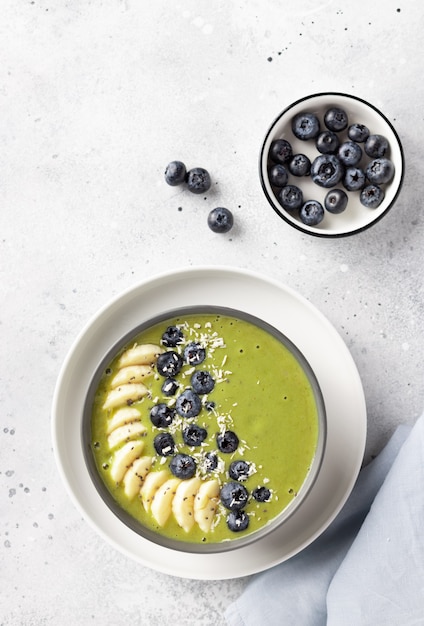 Ontbijt smoothie kom met groene matcha, banaan, bosbessen. veganistisch eten