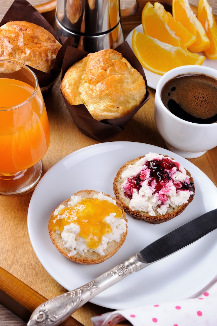Ontbijt van broodje met ricotta sinaasappel en kersenjam