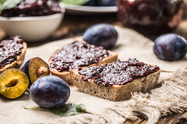 Ontbijt van huisgemaakt pruimenjambrood en verse rijpe pruimen.