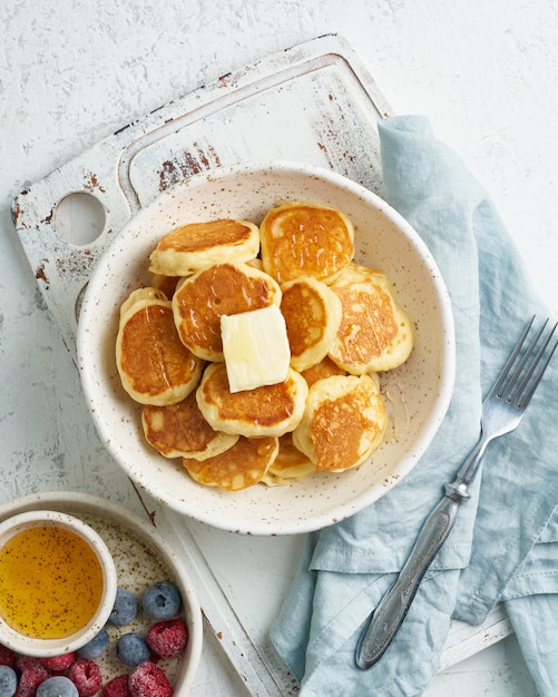 Ontbijtgranen voor pannenkoeken, kleine dunne grappige crumpet, kindervoeding. Ontbijt met drankje, witte tafel