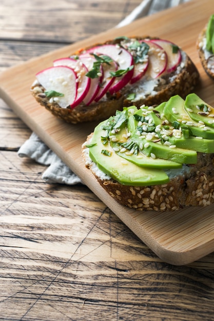 Foto ontbijtgranenbroodjes met kwark, verse avocado en radijs.