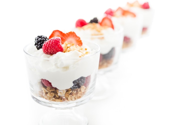 Ontbijtparfait gemaakt van Griekse yoghurt en granola met daarop verse bessen.